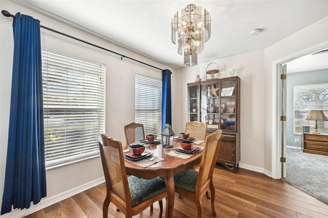 dining space with a chandelier, plenty of natural light, and hardwood / wood-style floors