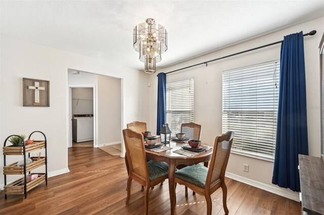 dining space featuring a notable chandelier, dark hardwood / wood-style flooring, and washer / dryer