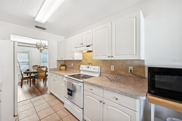 kitchen featuring backsplash, white appliances, pendant lighting, white cabinets, and light hardwood / wood-style floors