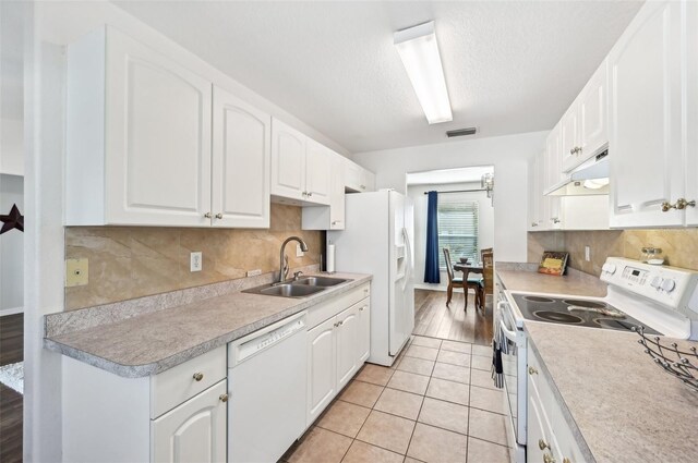 kitchen with white cabinetry, white appliances, and sink