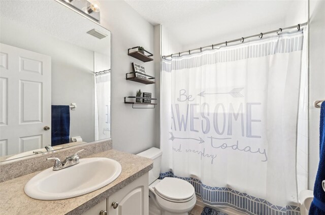 full bathroom featuring vanity, shower / bath combination with curtain, toilet, and a textured ceiling