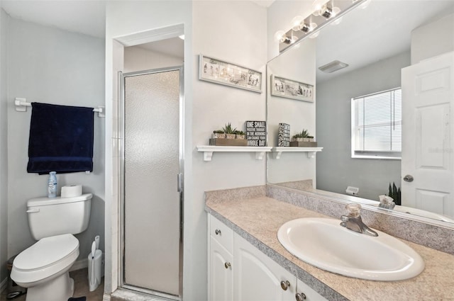 bathroom with vanity, toilet, and a shower with door