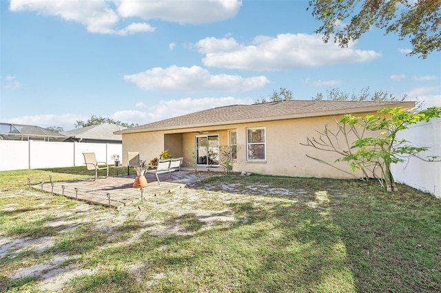 back of property featuring a lawn and a patio