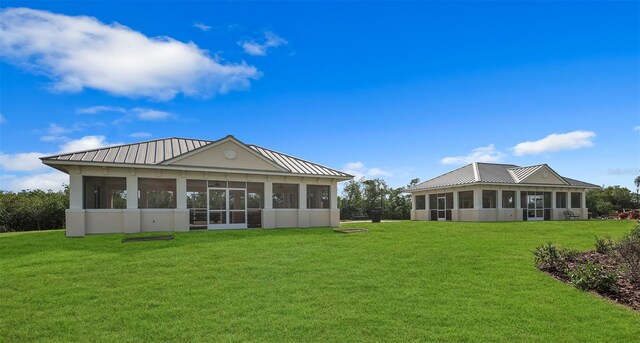 rear view of property featuring a sunroom and a yard