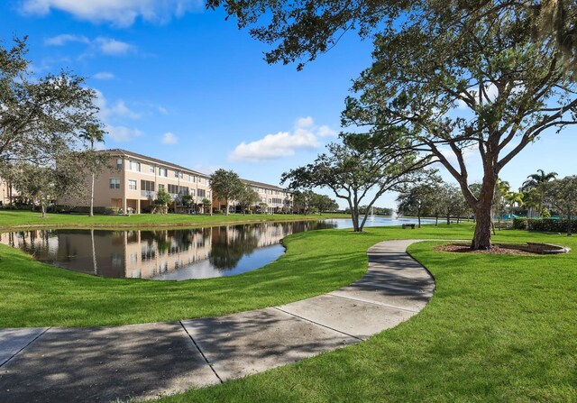 view of home's community with a water view and a lawn