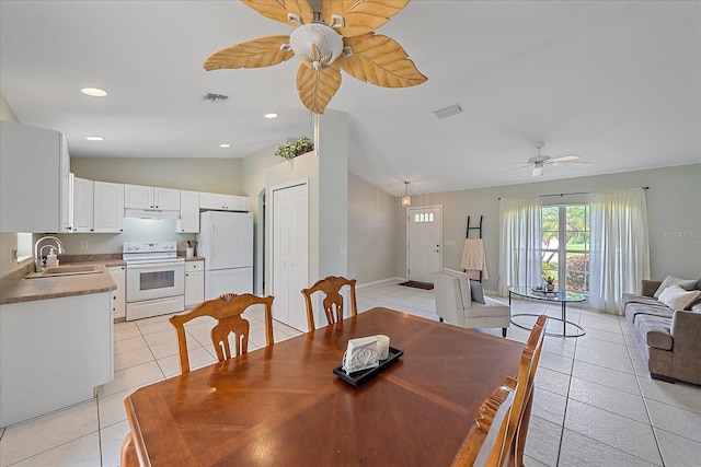 dining room with light tile patterned flooring, lofted ceiling, sink, and ceiling fan