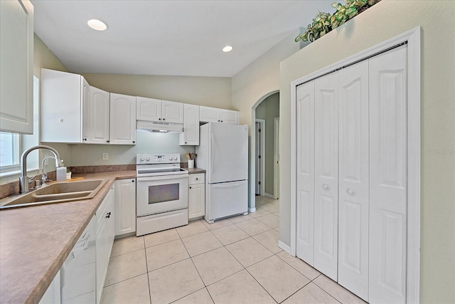 kitchen with lofted ceiling, sink, white cabinets, light tile patterned floors, and white appliances