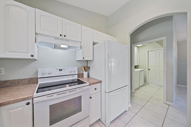 kitchen with white cabinetry, white appliances, light tile patterned floors, and washing machine and clothes dryer