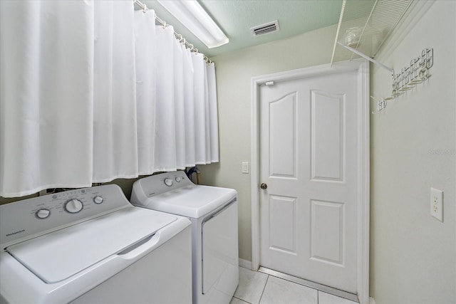 washroom with light tile patterned flooring and washing machine and clothes dryer