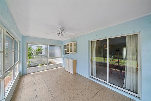 unfurnished sunroom with ceiling fan