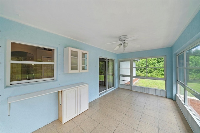 unfurnished sunroom with ceiling fan