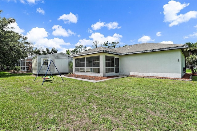 rear view of property featuring a yard and a sunroom