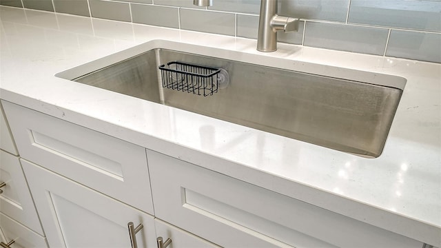 room details featuring tasteful backsplash and white cabinets