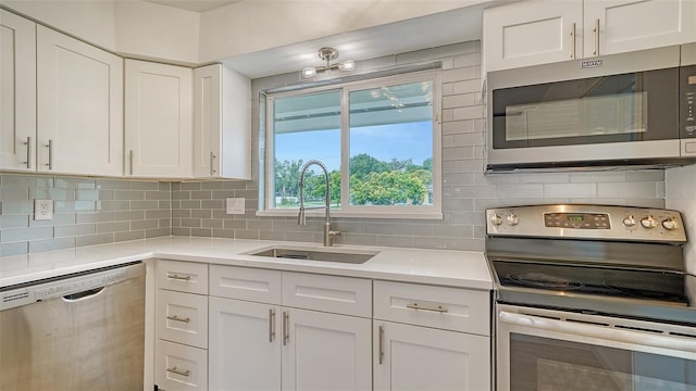 kitchen with white cabinetry, backsplash, appliances with stainless steel finishes, and sink