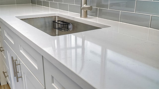 interior details with white cabinetry and backsplash