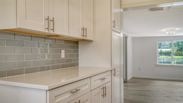 kitchen with decorative backsplash, light hardwood / wood-style flooring, and white cabinets