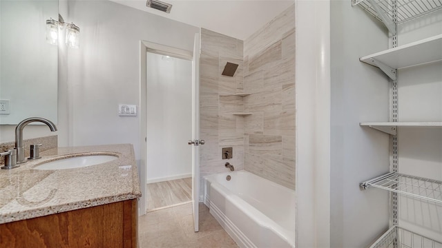 bathroom with tile patterned floors, vanity, and tiled shower / bath