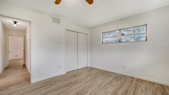 unfurnished bedroom featuring a closet, light wood-type flooring, and ceiling fan