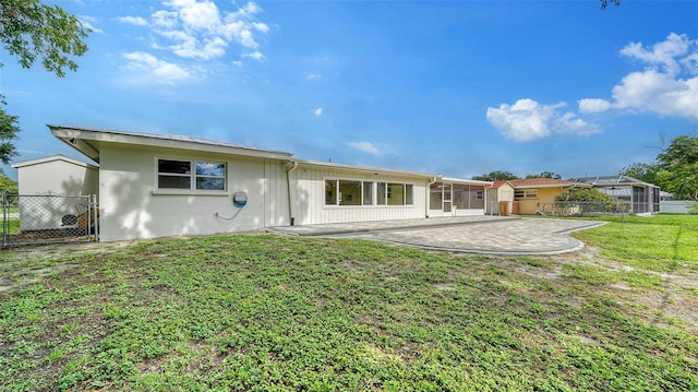 back of house featuring a patio and a yard