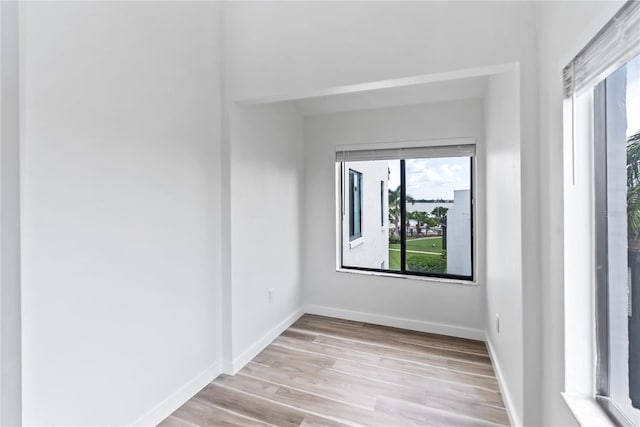 spare room featuring wood finished floors and baseboards