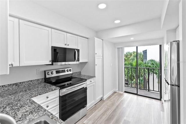 kitchen featuring white cabinetry, appliances with stainless steel finishes, and dark stone counters