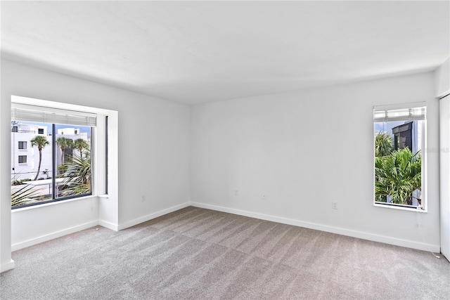 empty room featuring carpet and baseboards