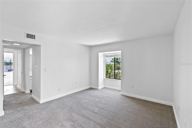 unfurnished room featuring carpet floors, baseboards, and visible vents