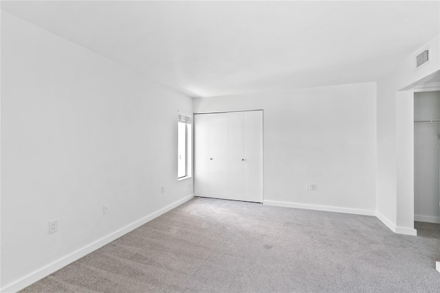 unfurnished bedroom with baseboards, visible vents, and carpet flooring