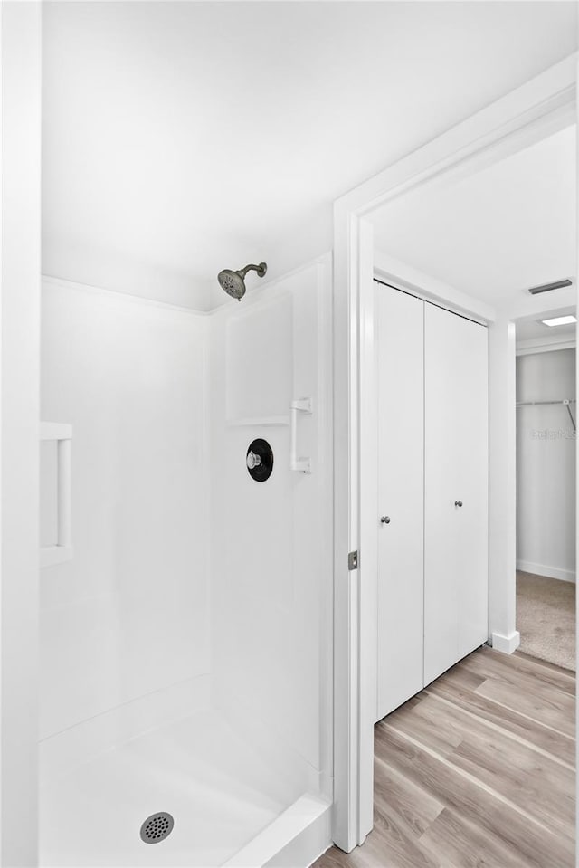 bathroom featuring a stall shower, visible vents, and wood finished floors