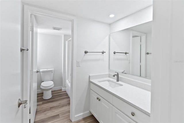 bathroom with visible vents, toilet, wood finished floors, bathtub / shower combination, and vanity