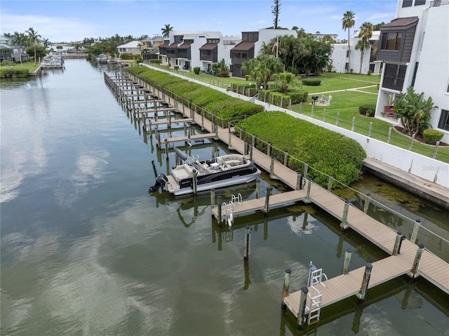 dock area with a water view, a residential view, and a yard