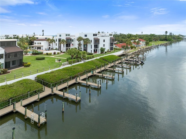 dock area with a water view, a yard, and fence