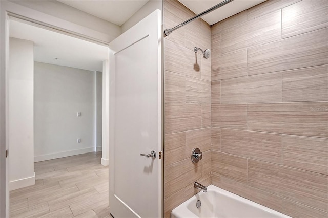 bathroom with tiled shower / bath and tile patterned flooring