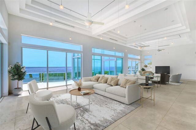 living room featuring ceiling fan, a water view, light tile patterned floors, and plenty of natural light