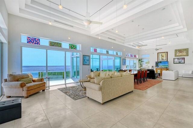 living room with plenty of natural light, a water view, light tile patterned flooring, and ceiling fan