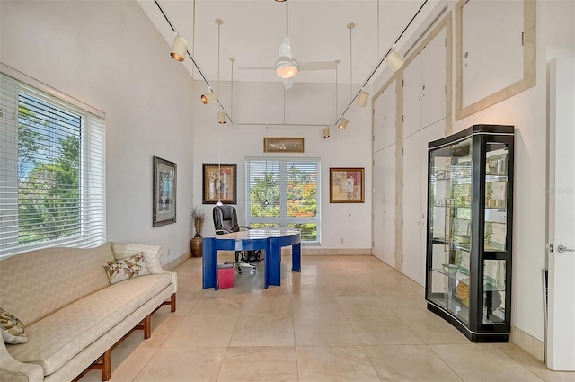 tiled office featuring ceiling fan and a high ceiling