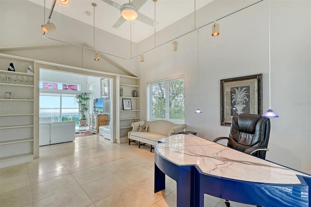 tiled living room featuring built in shelves, ceiling fan, a healthy amount of sunlight, and vaulted ceiling