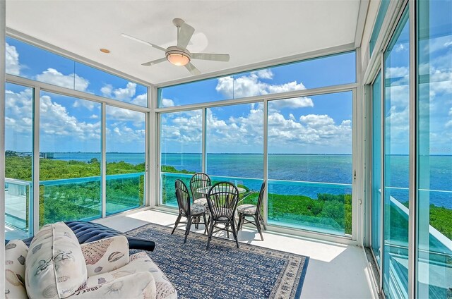 sunroom / solarium featuring a water view, ceiling fan, and a wealth of natural light