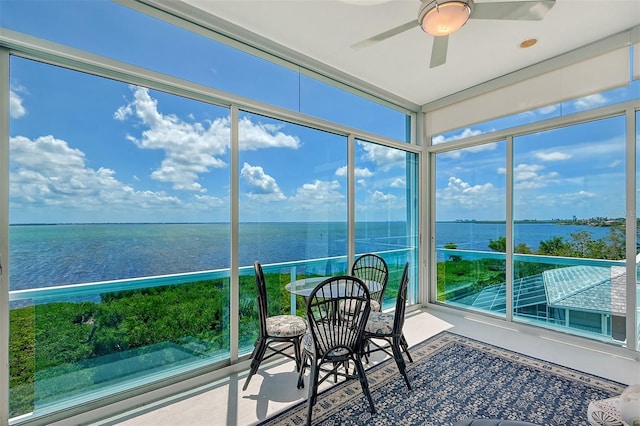 unfurnished sunroom featuring a water view, plenty of natural light, and ceiling fan