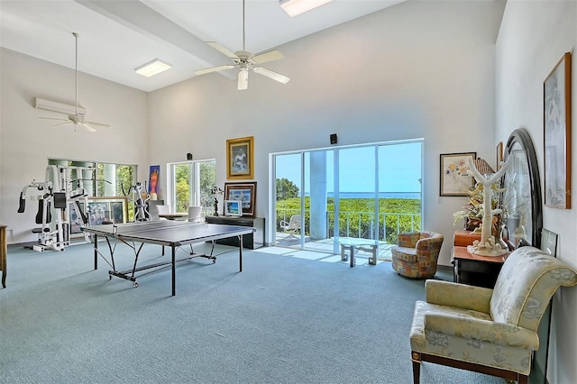 game room featuring carpet floors, ceiling fan, and a towering ceiling