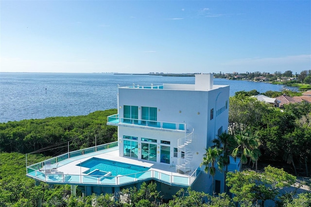 back of house featuring a fenced in pool, a balcony, and a water view