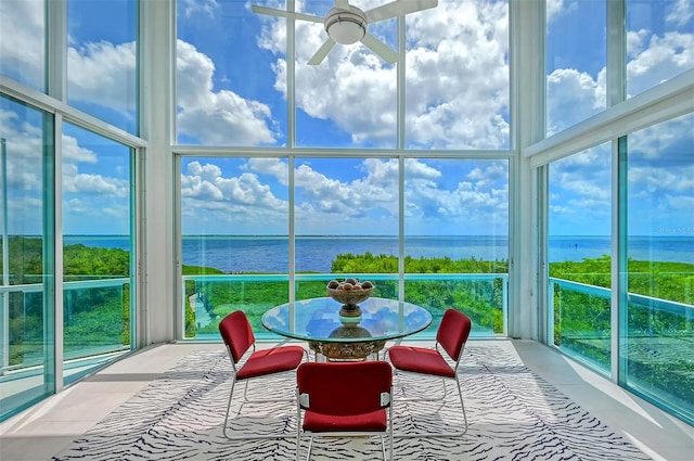 sunroom / solarium featuring a water view and ceiling fan