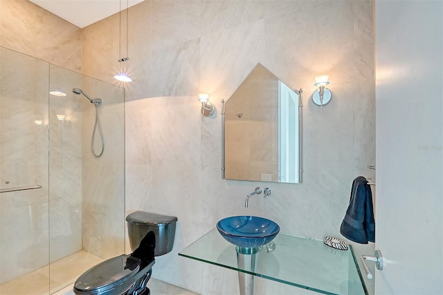 bathroom featuring sink, tiled shower, and tile walls