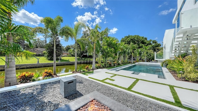 view of swimming pool with a fire pit, a water view, and a patio area