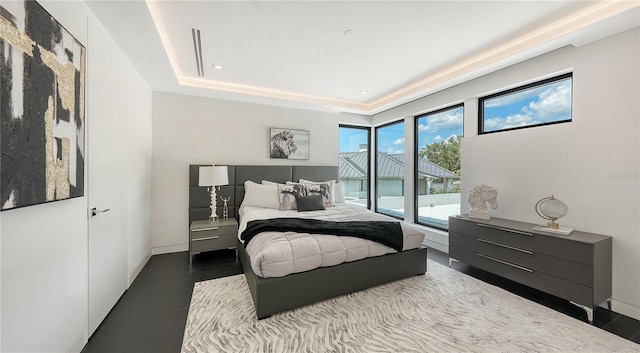 bedroom featuring hardwood / wood-style flooring and a tray ceiling