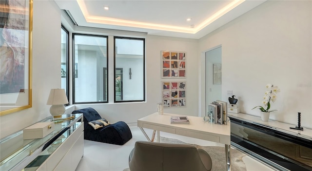 office space featuring light tile patterned flooring and a tray ceiling