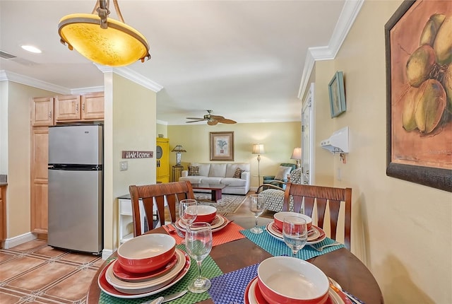 tiled dining space with ceiling fan and crown molding