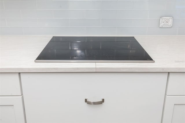 interior details featuring black electric stovetop and white cabinets