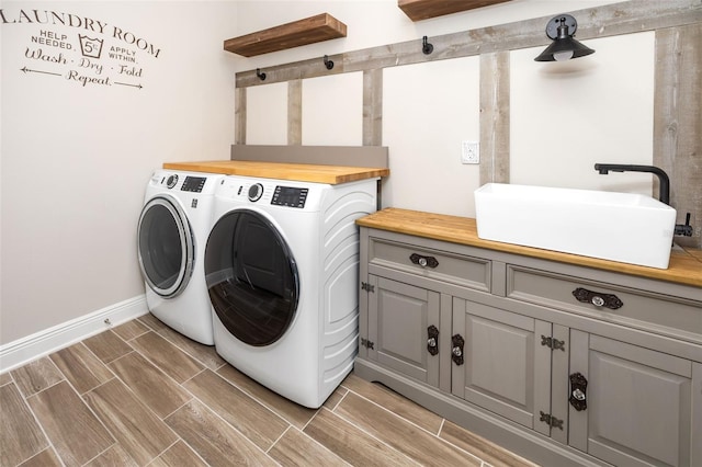 laundry room with cabinets, separate washer and dryer, and sink