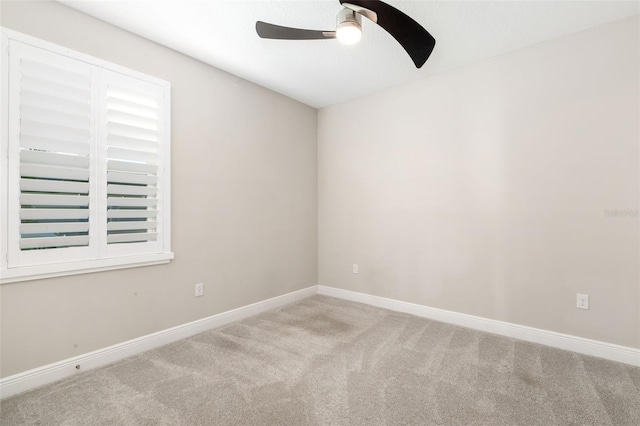 carpeted spare room featuring ceiling fan